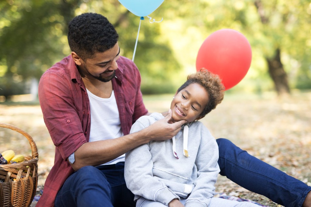 A father laughing with his family outdoors